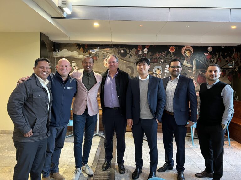 Management Team Unites Before a Striking Mural