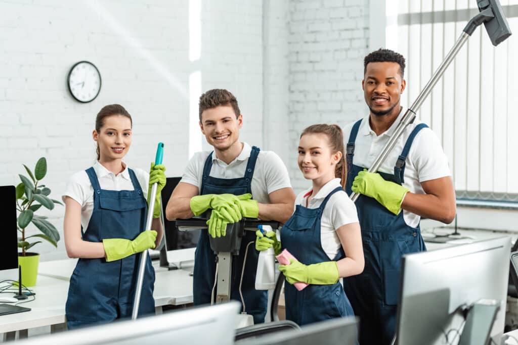 Dedicated workers maintain a clean office environment, featuring modern workstations, cleaning professionals, and focused colleagues collaborating.