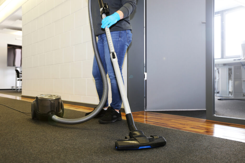Office,Cleaning:,Cleaner,Vacuums,The,Corridor,Of,An,Office