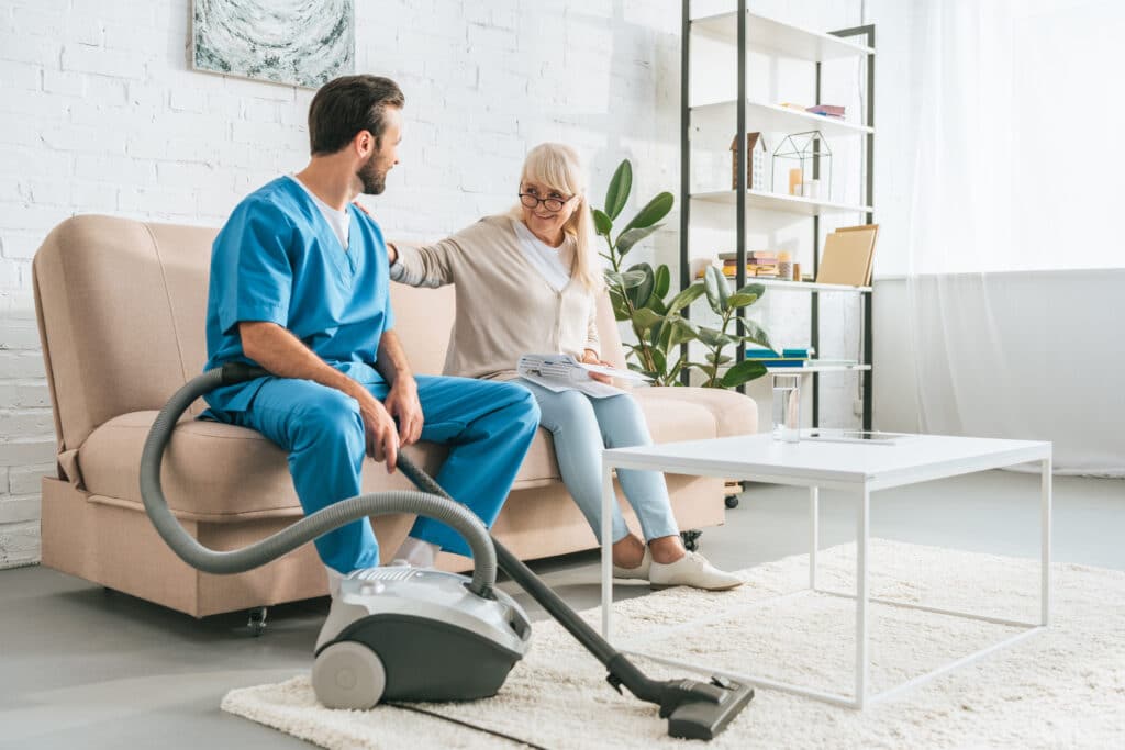 Smiling,Senior,Woman,Sitting,On,Couch,And,Looking,At,Social