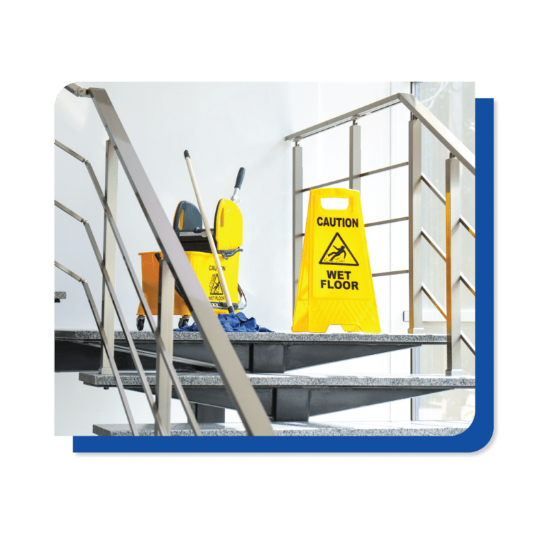 A yellow caution sign placed on the stairs of a building, warning of potential hazards or slippery conditions.