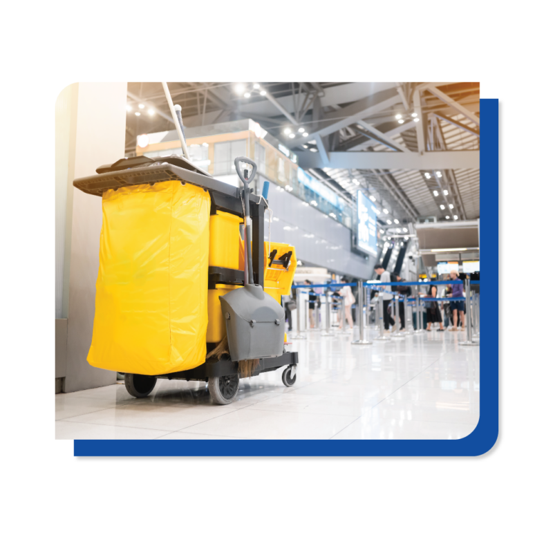 A yellow and black cleaning cart positioned in an airport, ready for use in maintaining cleanliness and order.