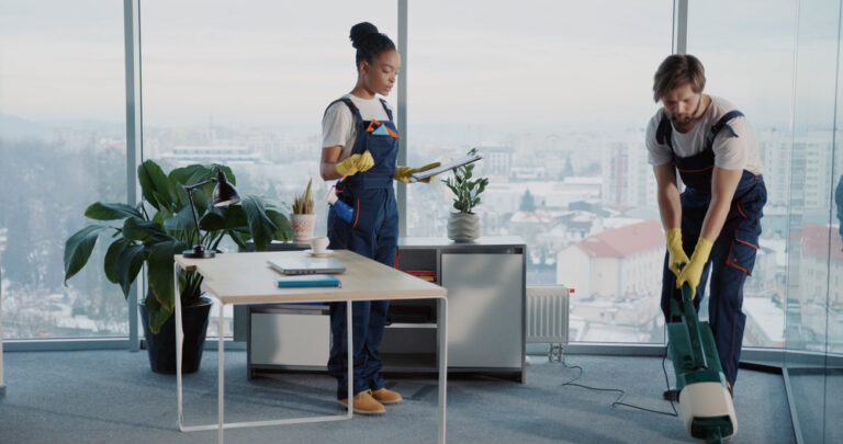 Professional cleaners performing office maintenance in a high-rise building, showcasing body corporate cleaning services